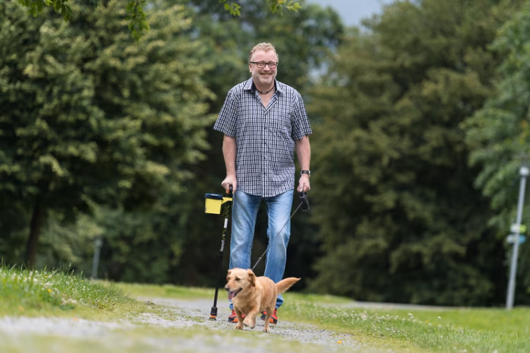 Reha Patient mit Gehhilfe und Hund